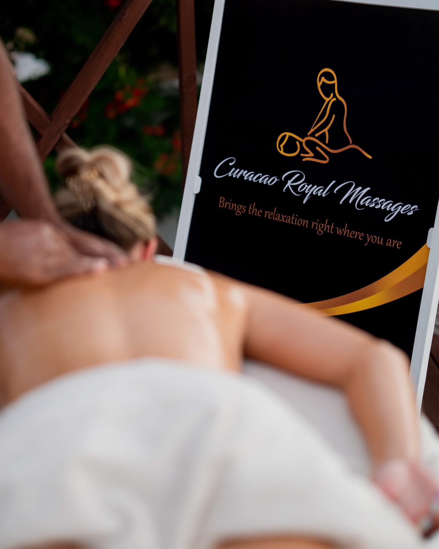 Een schoudermassage naast het logo van Curacao Royal Massages